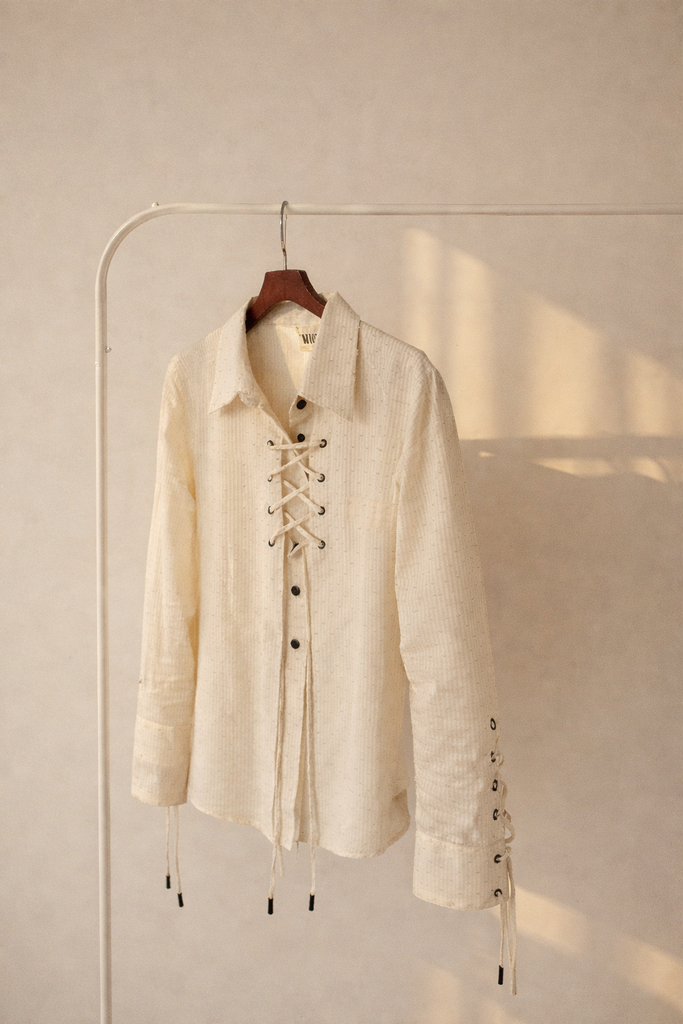 Lace-up blouse on minimalist rack.webp